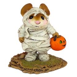 Young mouse wrapped in bandages carrying a pumpkin candy bucket