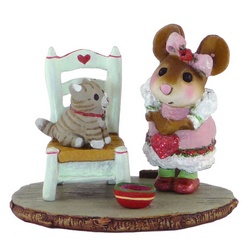 Young girl mouse with Valentine's heart looks at a kitten sitting on a chair