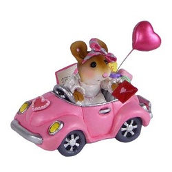 Girl in pink car with balloons holding a Valentine  card