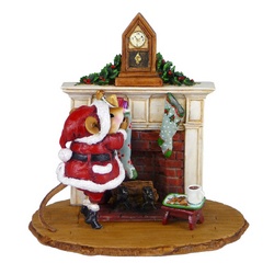 Santa in fromt of a fireplace fillling stockings