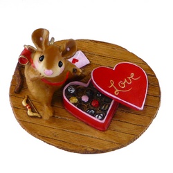Young mouse sitting on floor eating a box Valentine’s chocolates