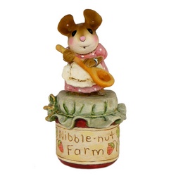 Tny mother mouse with wooden spoon standing on a jar of jam