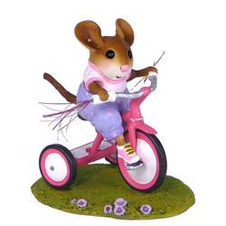 Young mouse riding a decorated trike