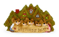 Five mice stand infront of forest home holding a WFF banner