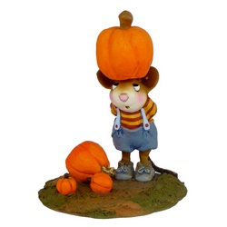 Boy mouse balances a large pumpkin on his head three others lie on the ground