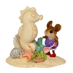 Sand sea horse sculpture by a young girl-mouse, surrounded with beach treasures