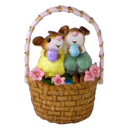 Apair of mice stting in an Easter basket with Easter eggs